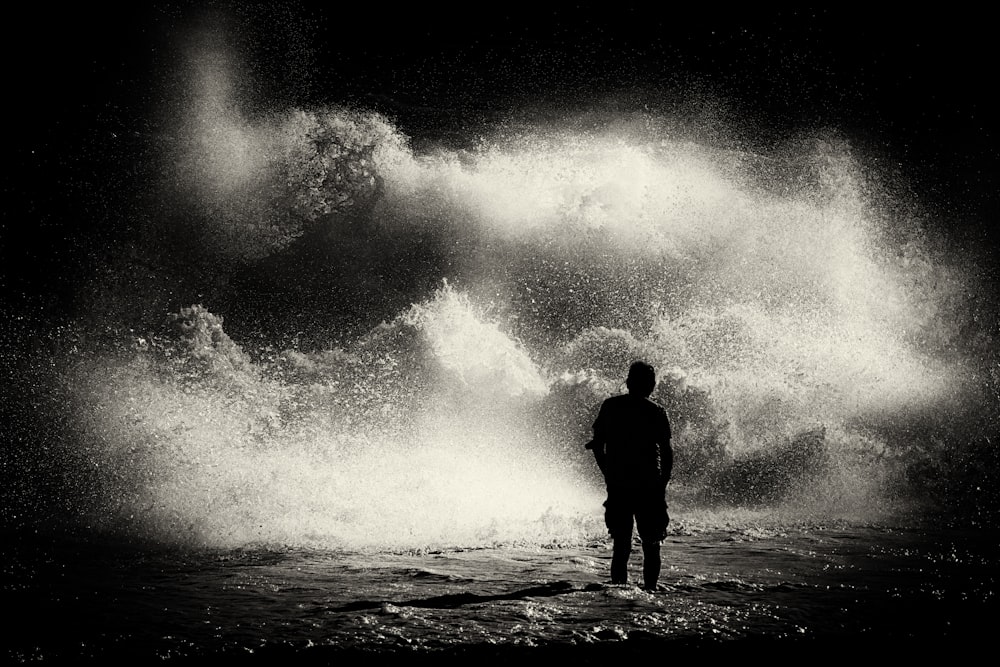 a man standing in front of a large wave
