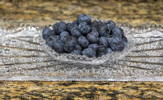 Fresh cranberries and blueberries nestled together in a rustic ceramic bowl.