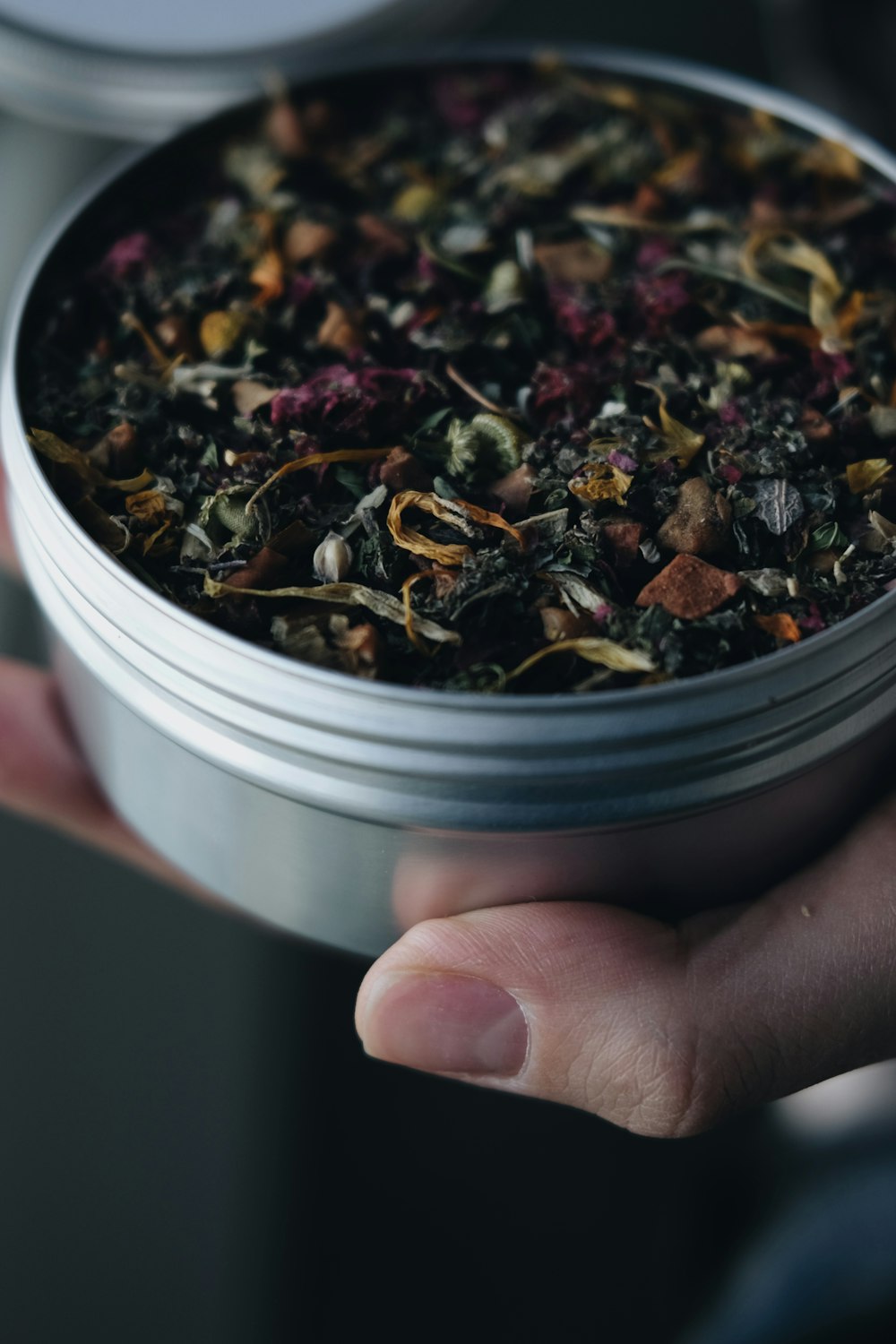 a person holding a tin of tea in their hand