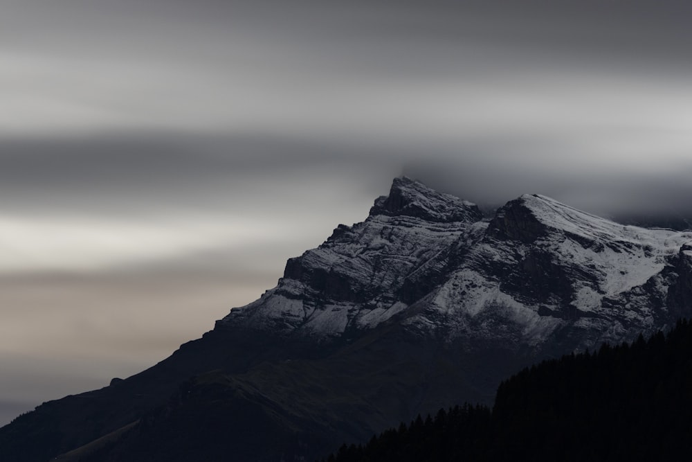 a snow covered mountain under a cloudy sky