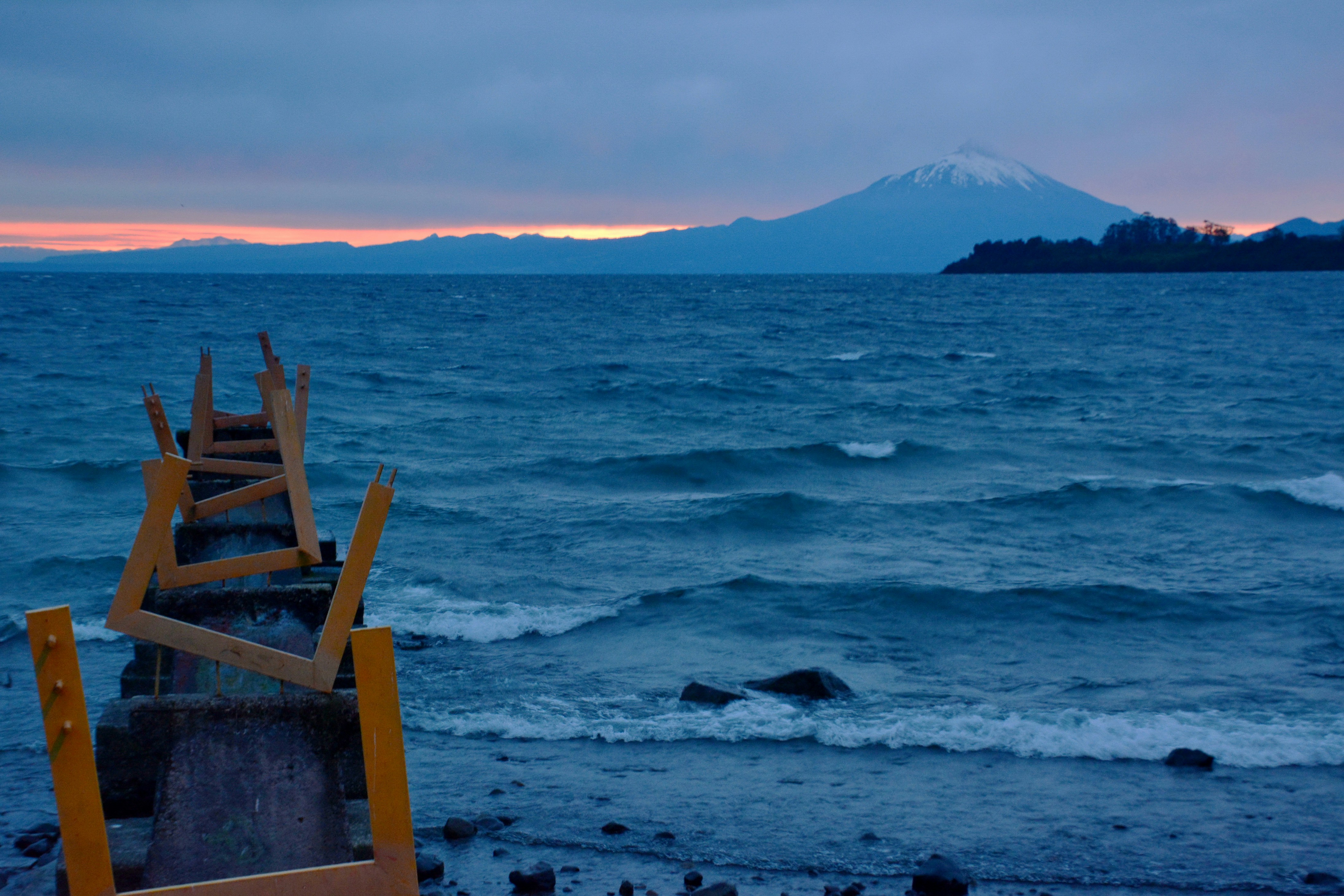 a row of wooden posts sitting on top of a beach