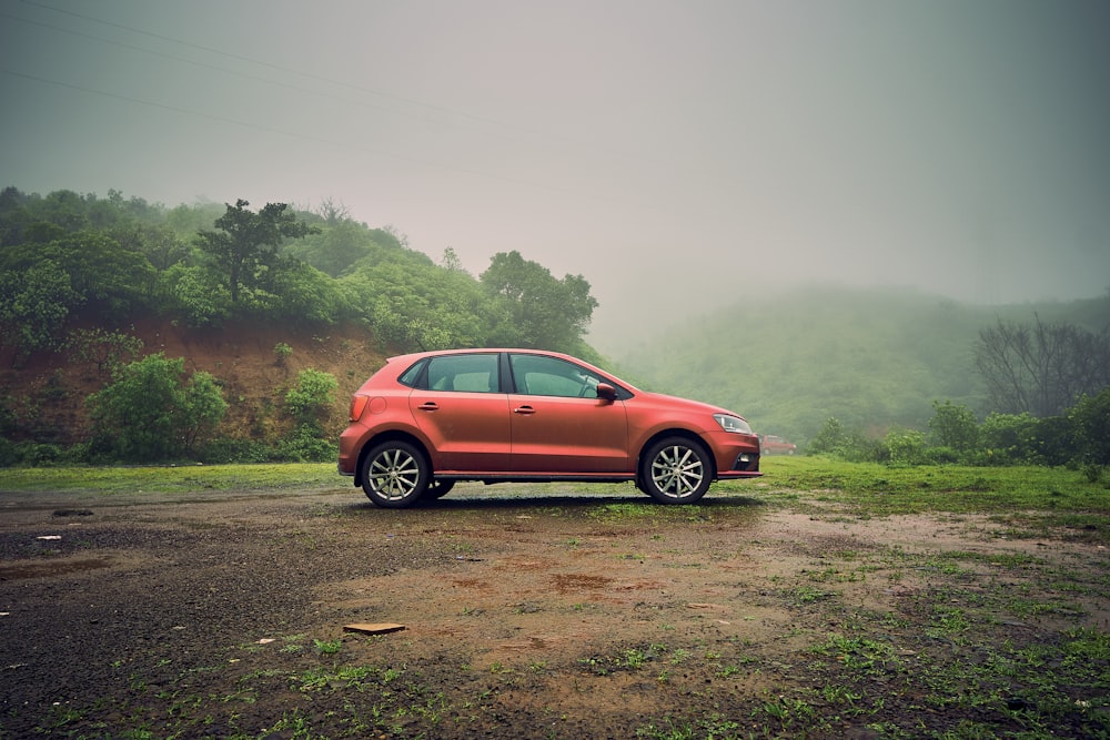 a red car is parked in a field