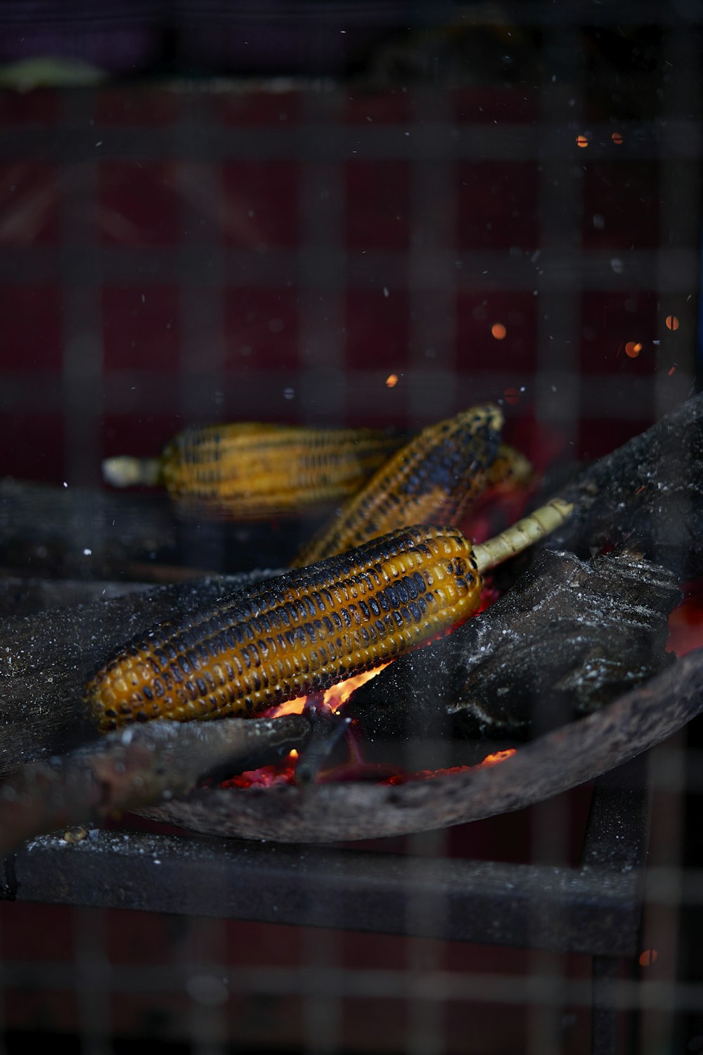 corn on the cob being cooked on a grill