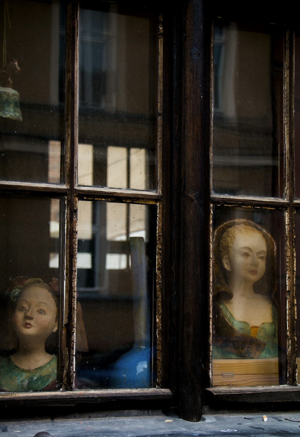 a close up of a window with a statue in it