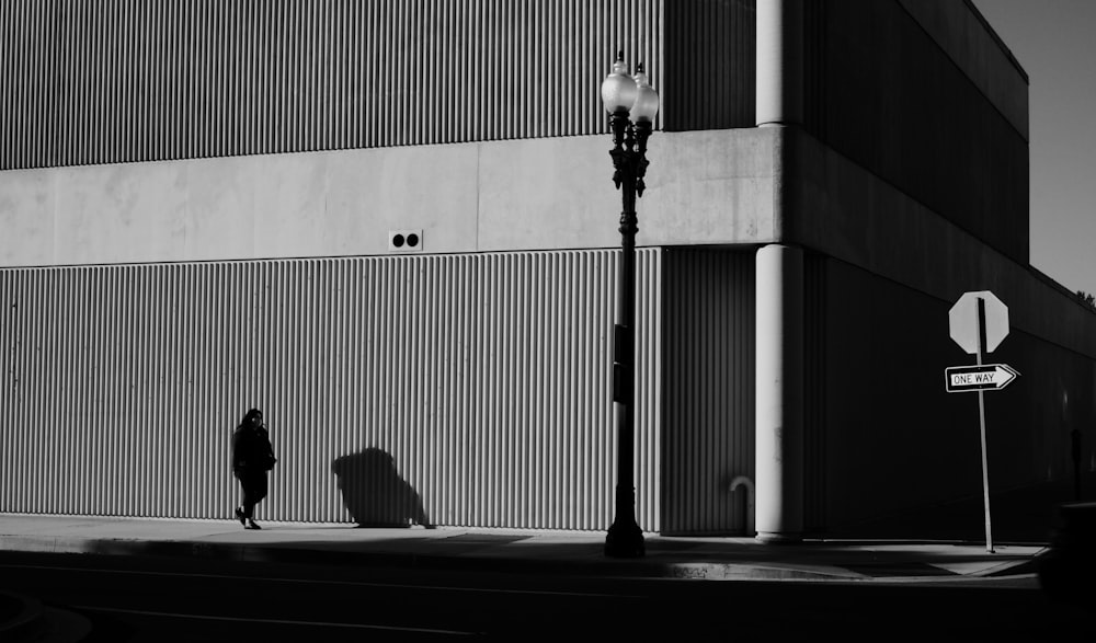 a person walking down a street next to a tall building