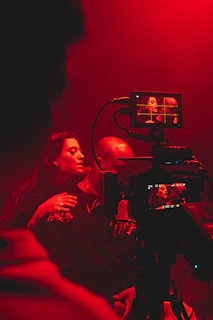 a woman is filming a man in a red light