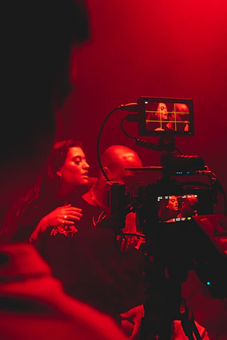 a woman is filming a man in a red light