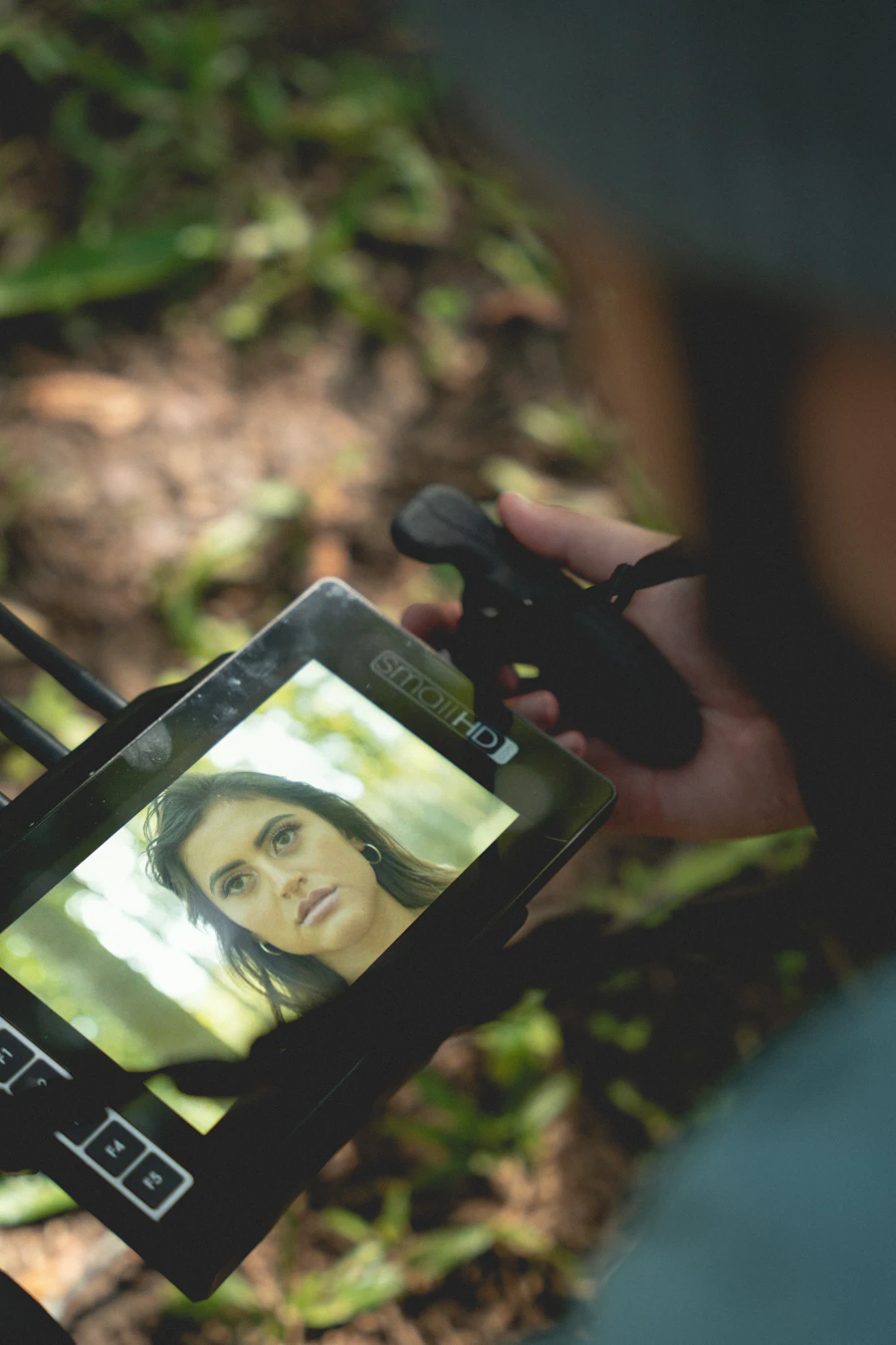 A phone held up showing a person speaking on screen