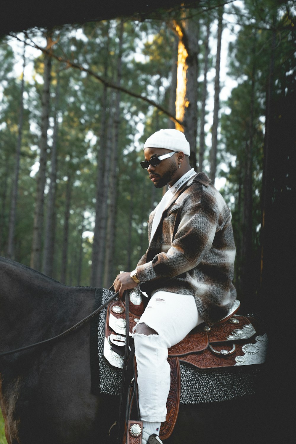 a man sitting on a horse in the woods