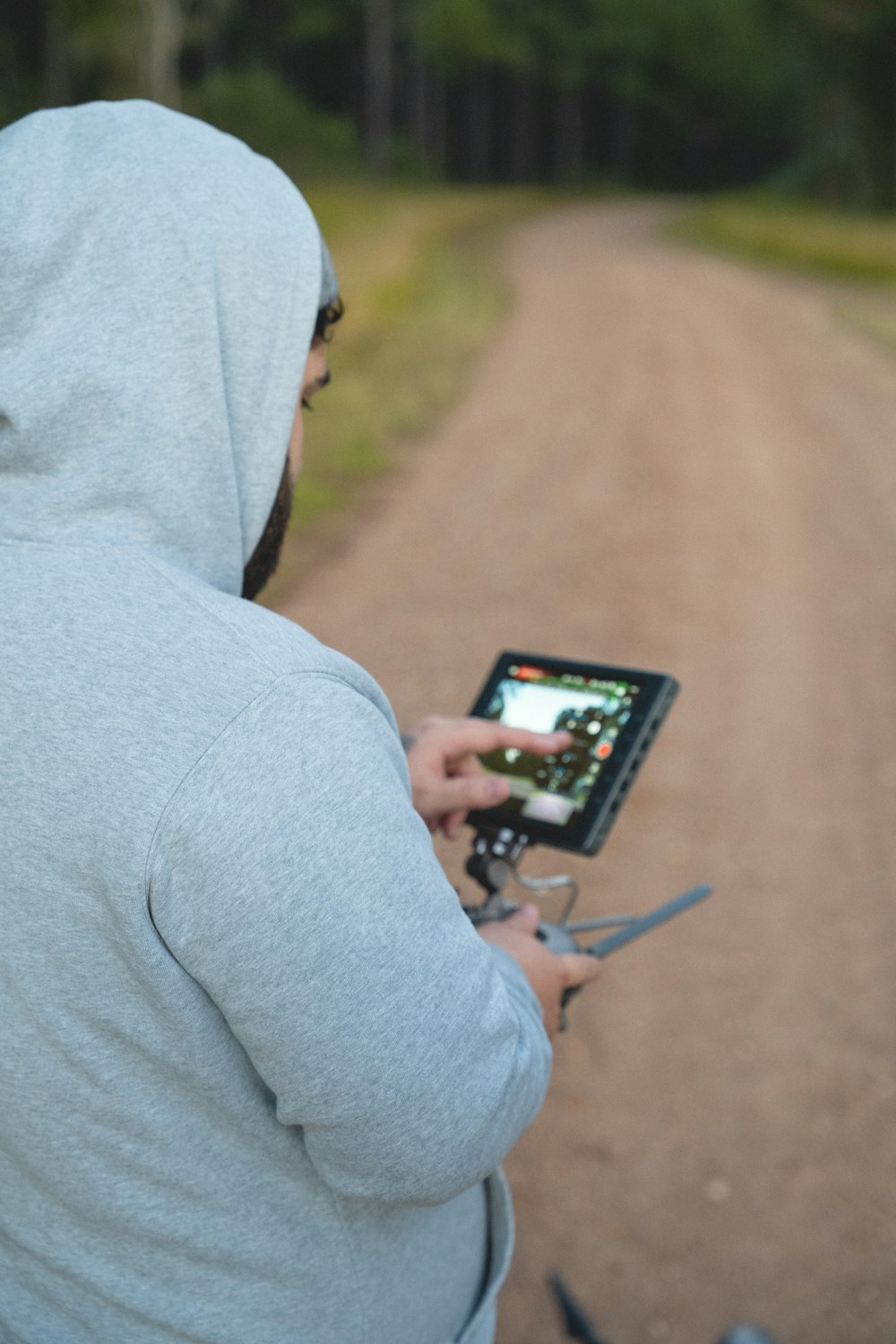 a person in a hoodie is holding a tablet