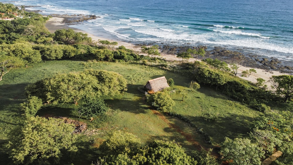 an aerial view of a house on a hill near the ocean