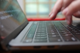 a close up of a person typing on a laptop