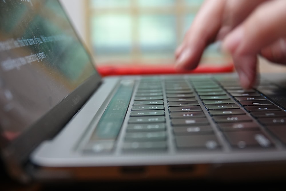 a close up of a person typing on a laptop