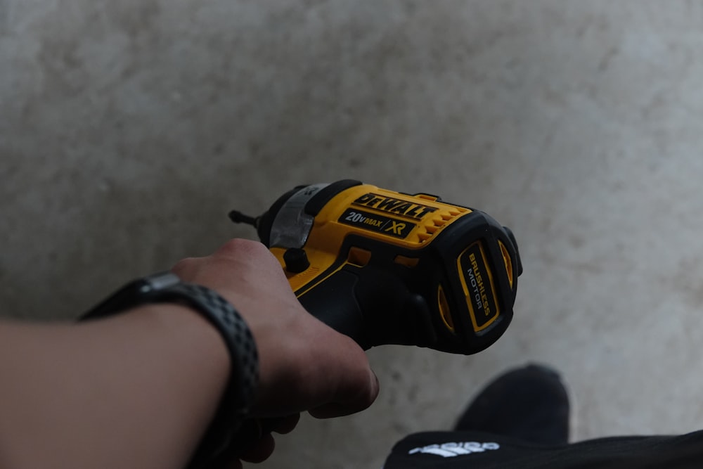 a person holding a cordless drill in their hand