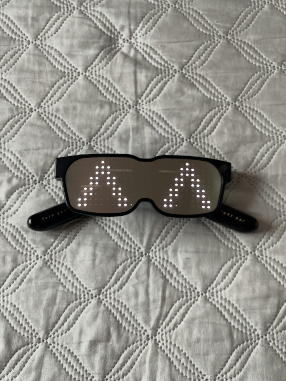 a pair of glasses laying on top of a bed