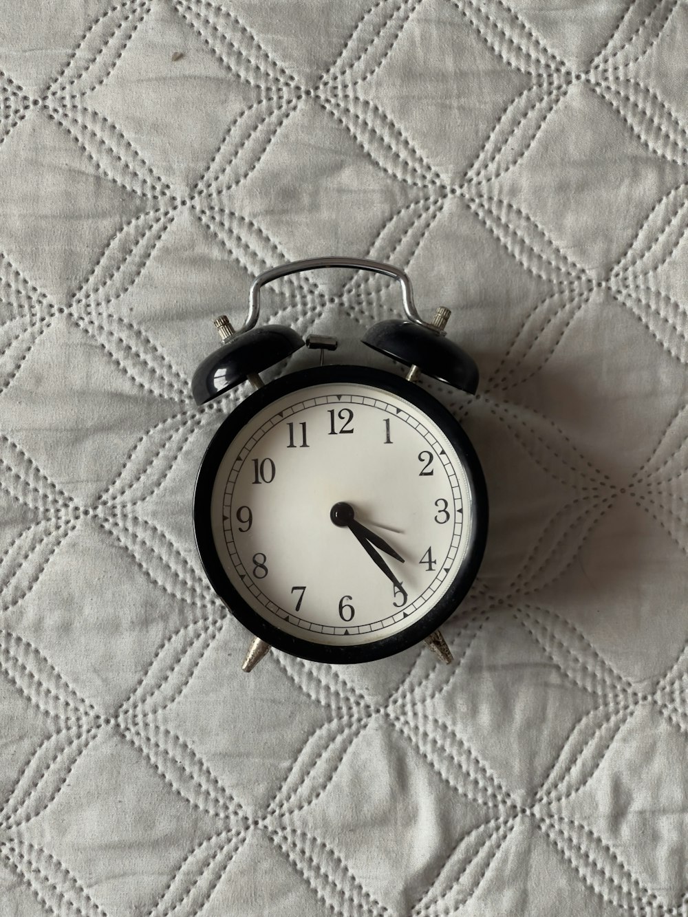 an alarm clock sitting on top of a bed