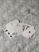 four playing cards are laying on a quilt