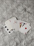 four playing cards are laying on a quilt
