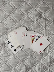 four playing cards are laying on a quilt