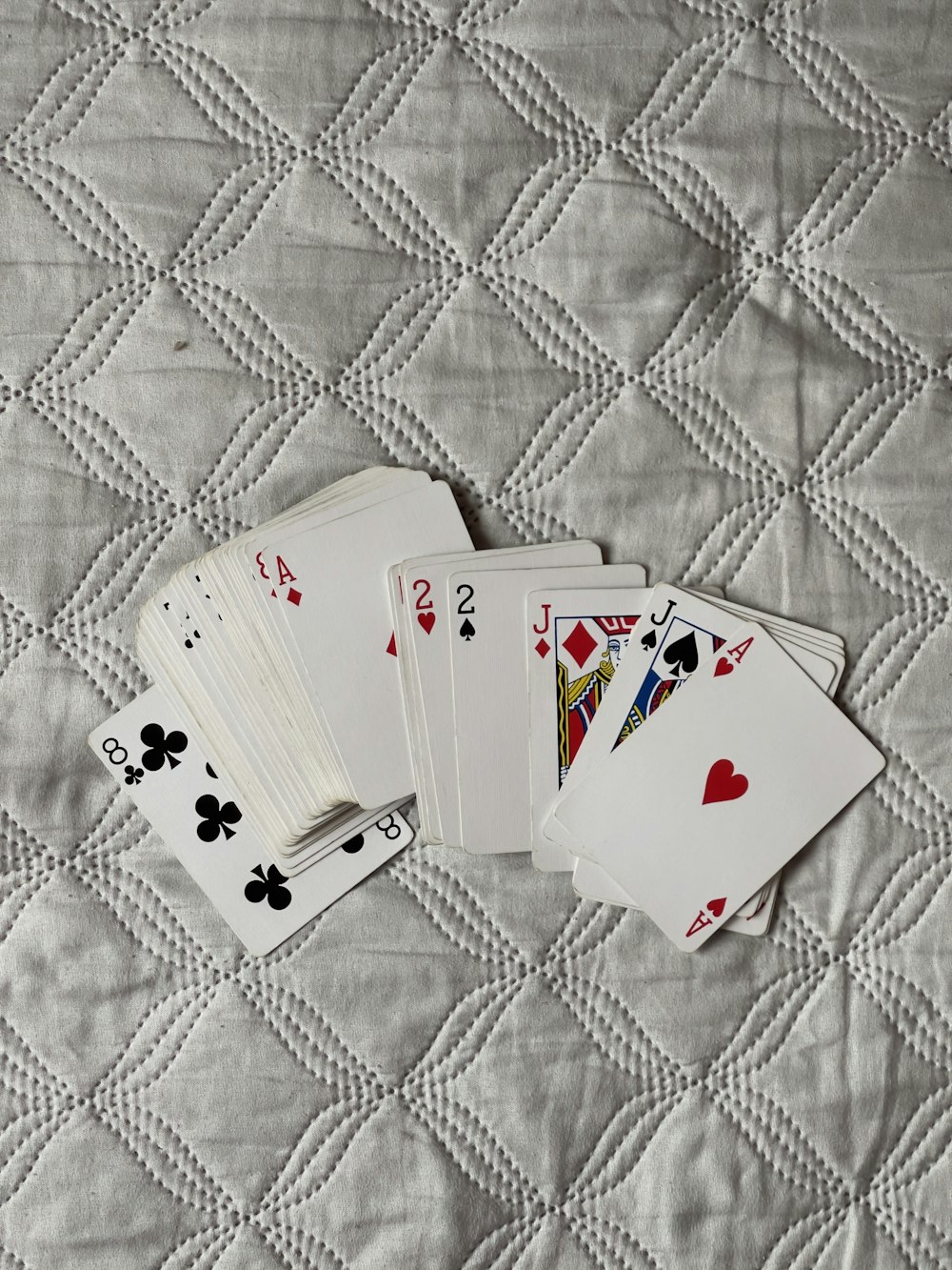 four playing cards are laying on a quilt