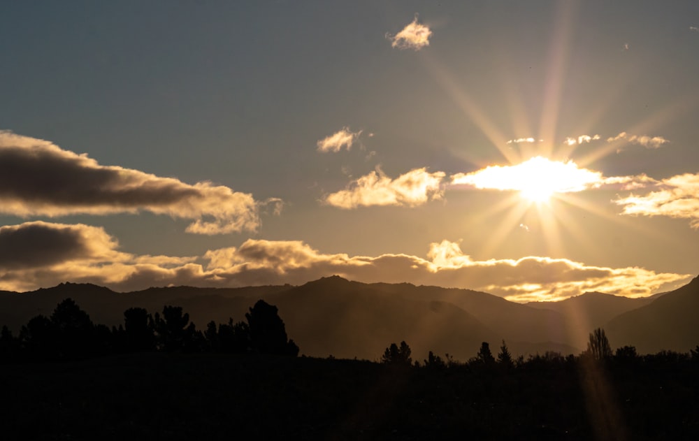 the sun is setting over a mountain range