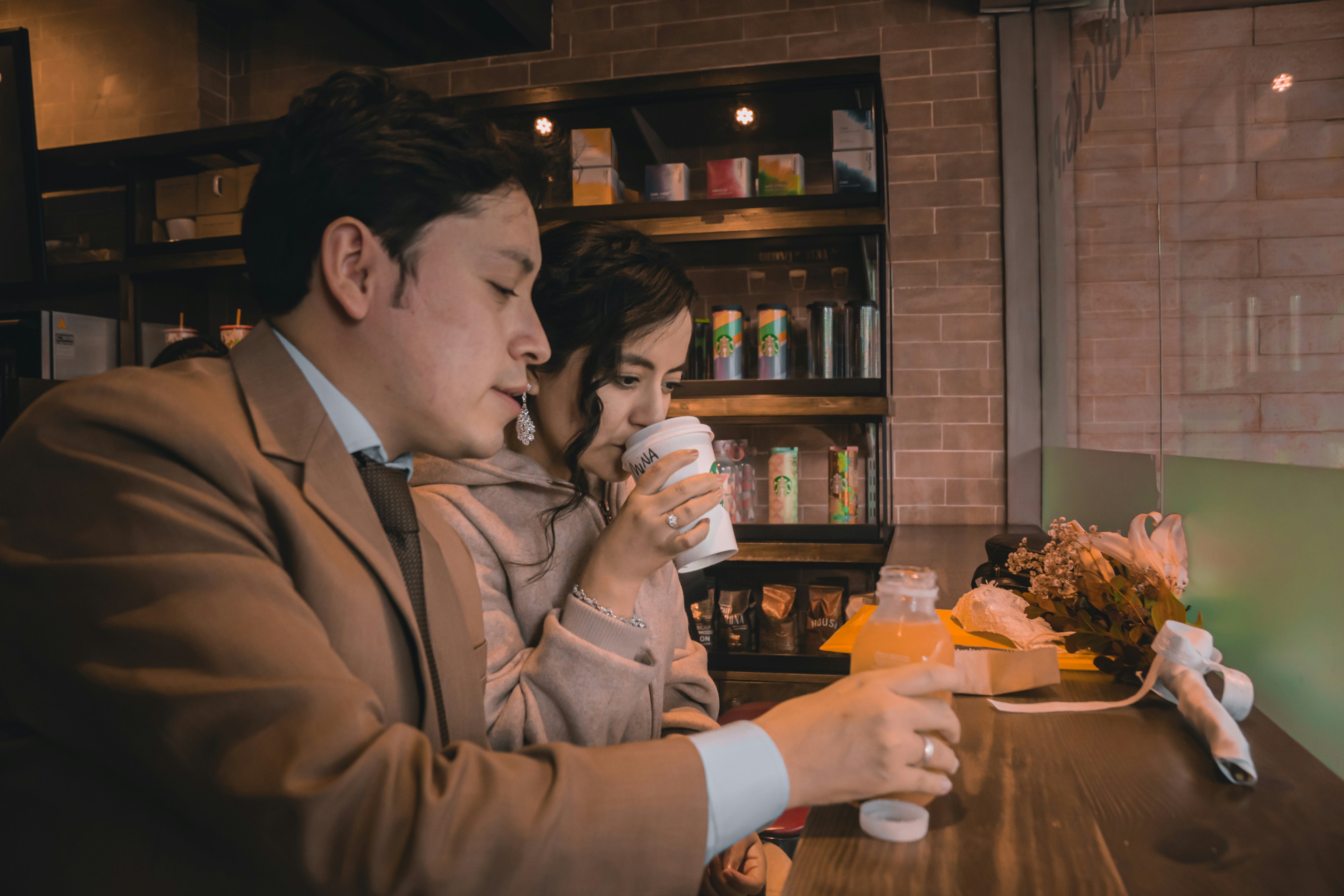 a man and woman sitting at a table drinking coffee