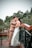 a bride and groom kissing on a bridge