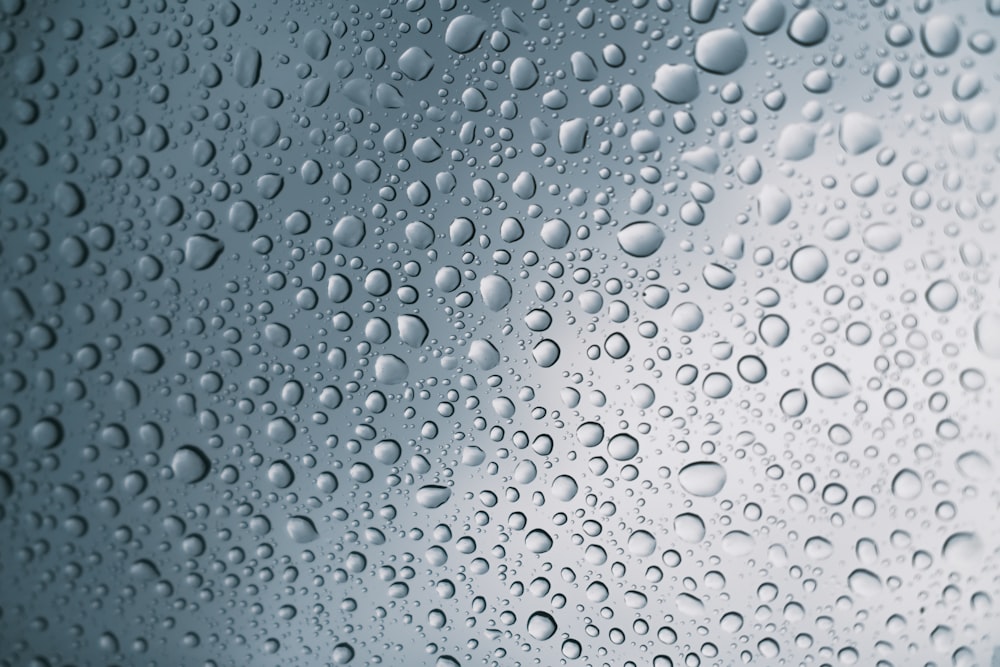 rain drops on a window with a blue sky in the background