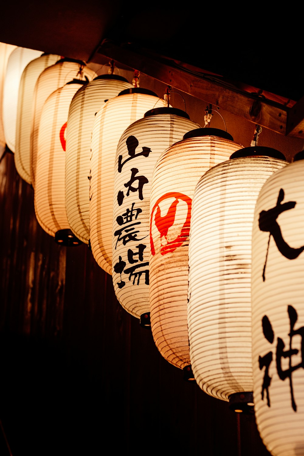 a row of lanterns with asian writing on them