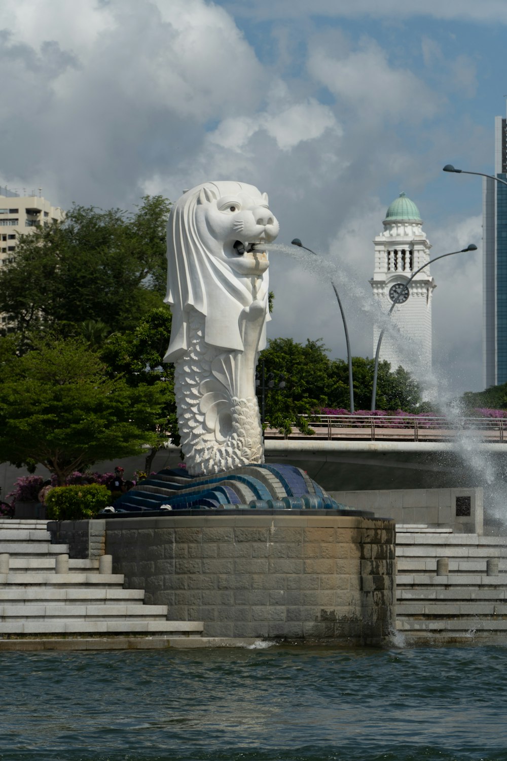 a large statue of a lion near a body of water