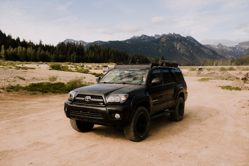 a black truck parked on a dirt road