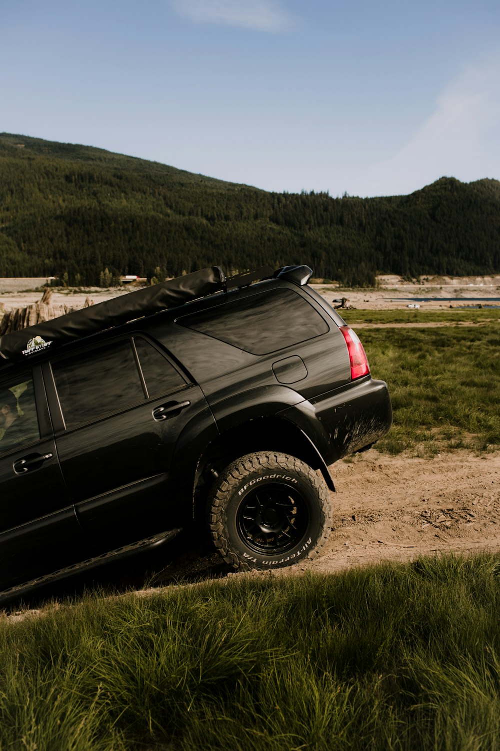 a black truck parked on a dirt road