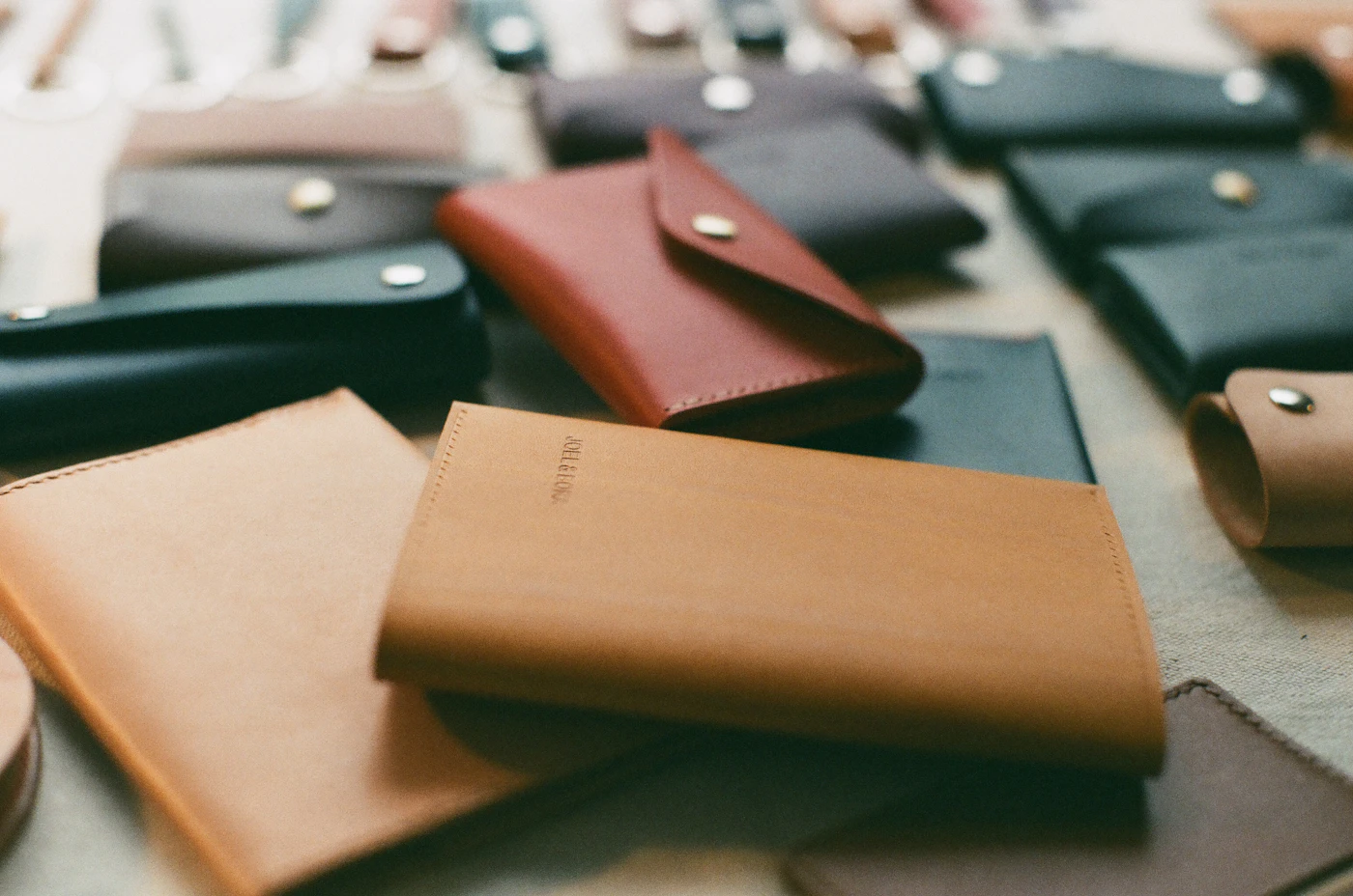 Plusieurs portefeuilles en cuir de teintes différentes alignés sur une table