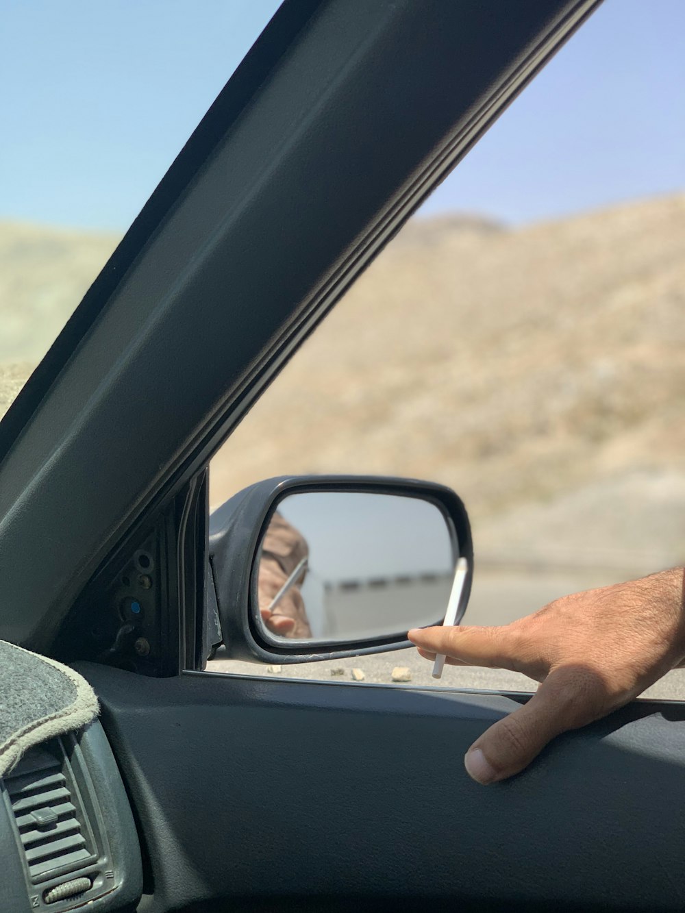 a man holding his hand out the window of a car