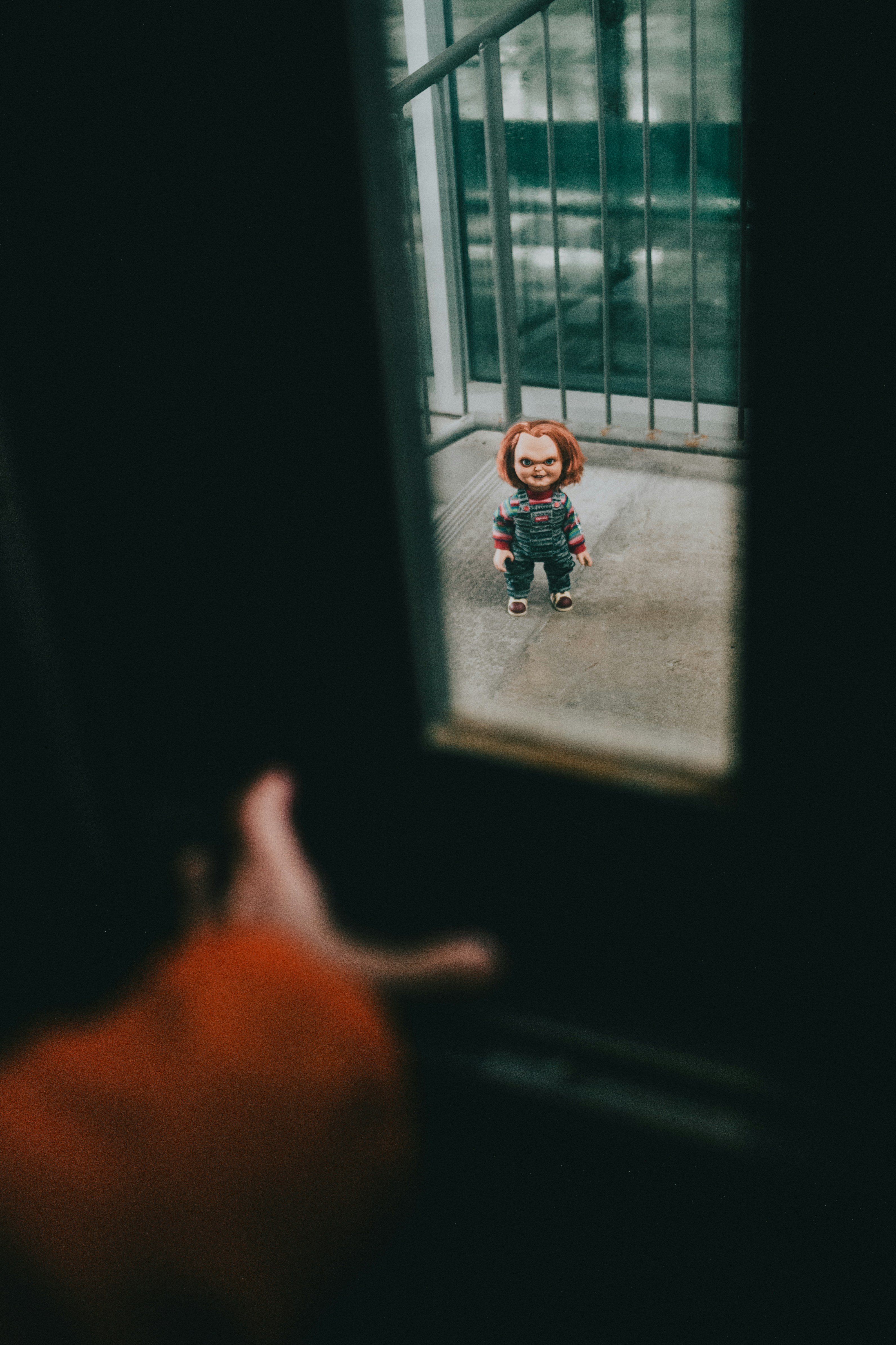 a small doll sitting in front of a window