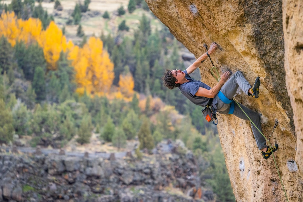 Un homme grimpant sur le flanc d’une montagne