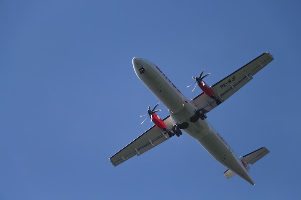 a small airplane flying through a blue sky