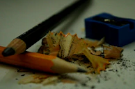 A vintage pencil sharpener next to a stack of hand-drawn illustrations.