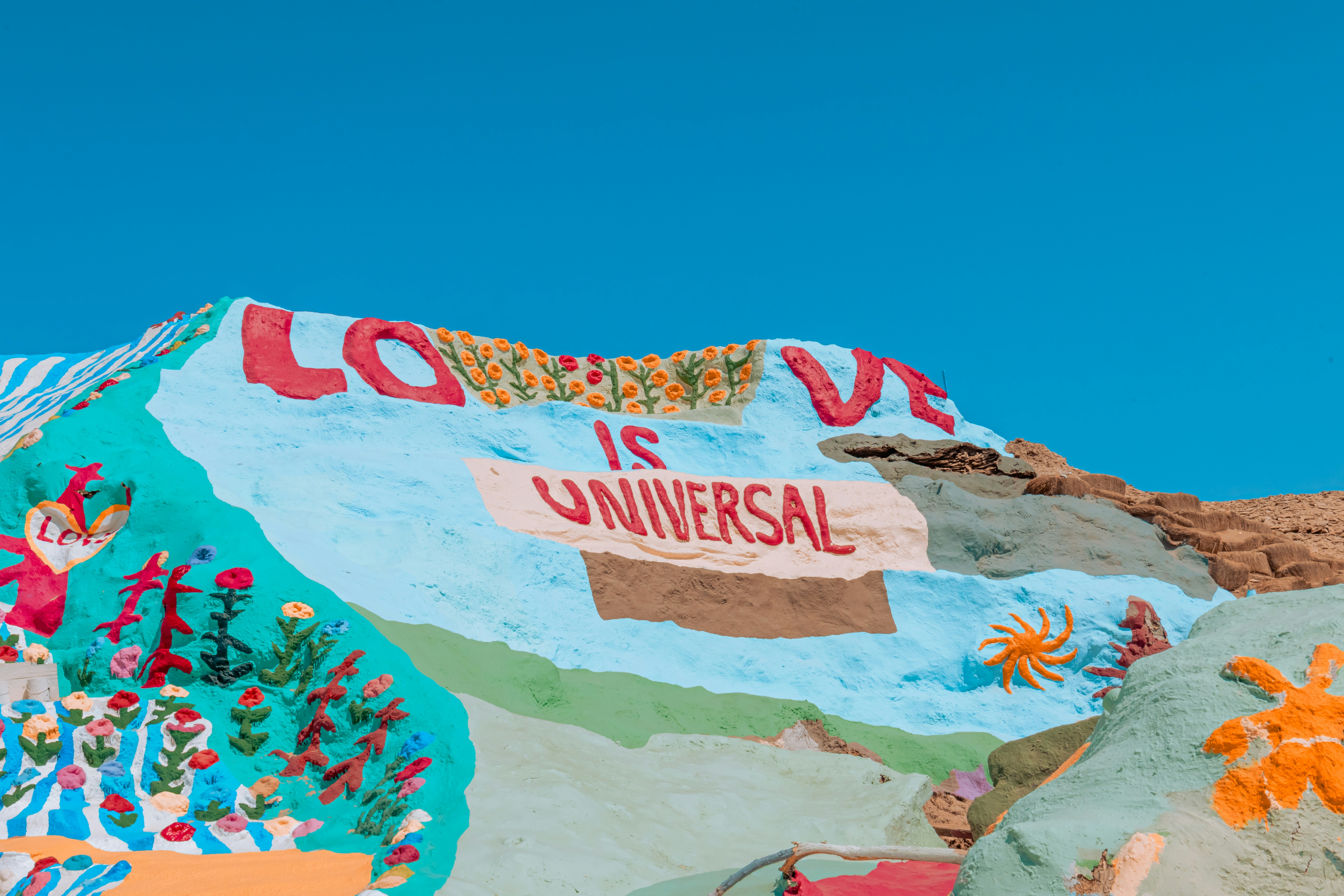 a colorfully painted mountain with a sign that says love is universal