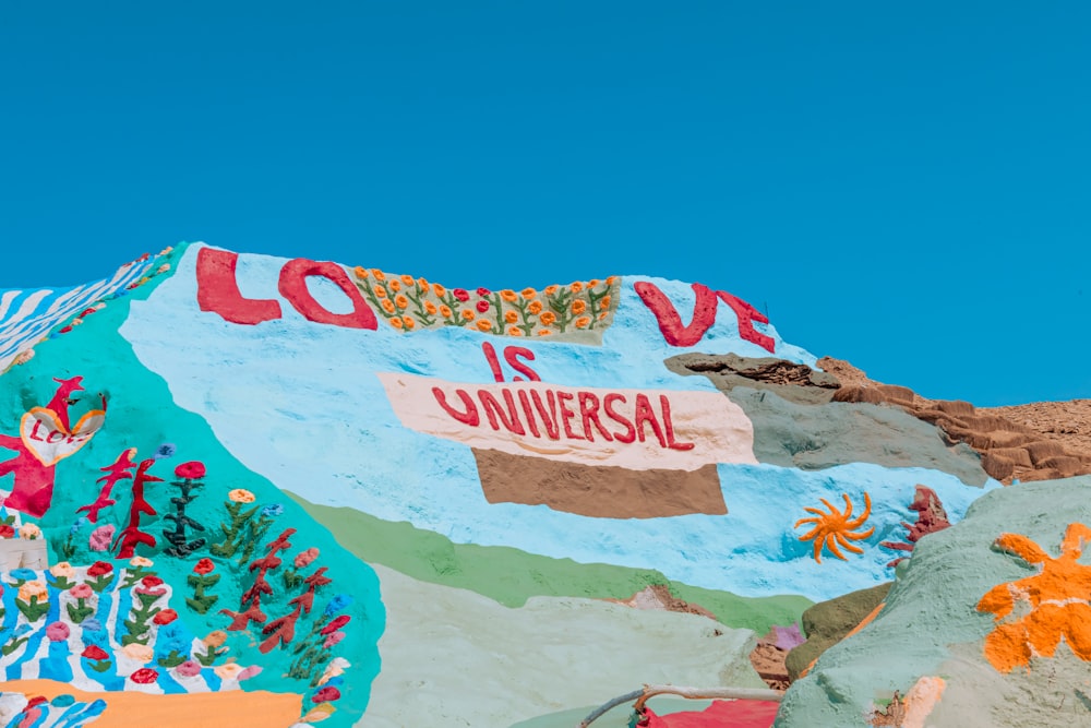 a colorfully painted mountain with a sign that says love is universal
