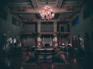A cinematic frame capturing a luxurious noir interior bathed in dark gradients and golden light reflections.