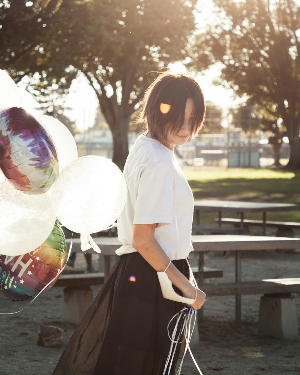 a woman standing in front of a picnic table with balloons