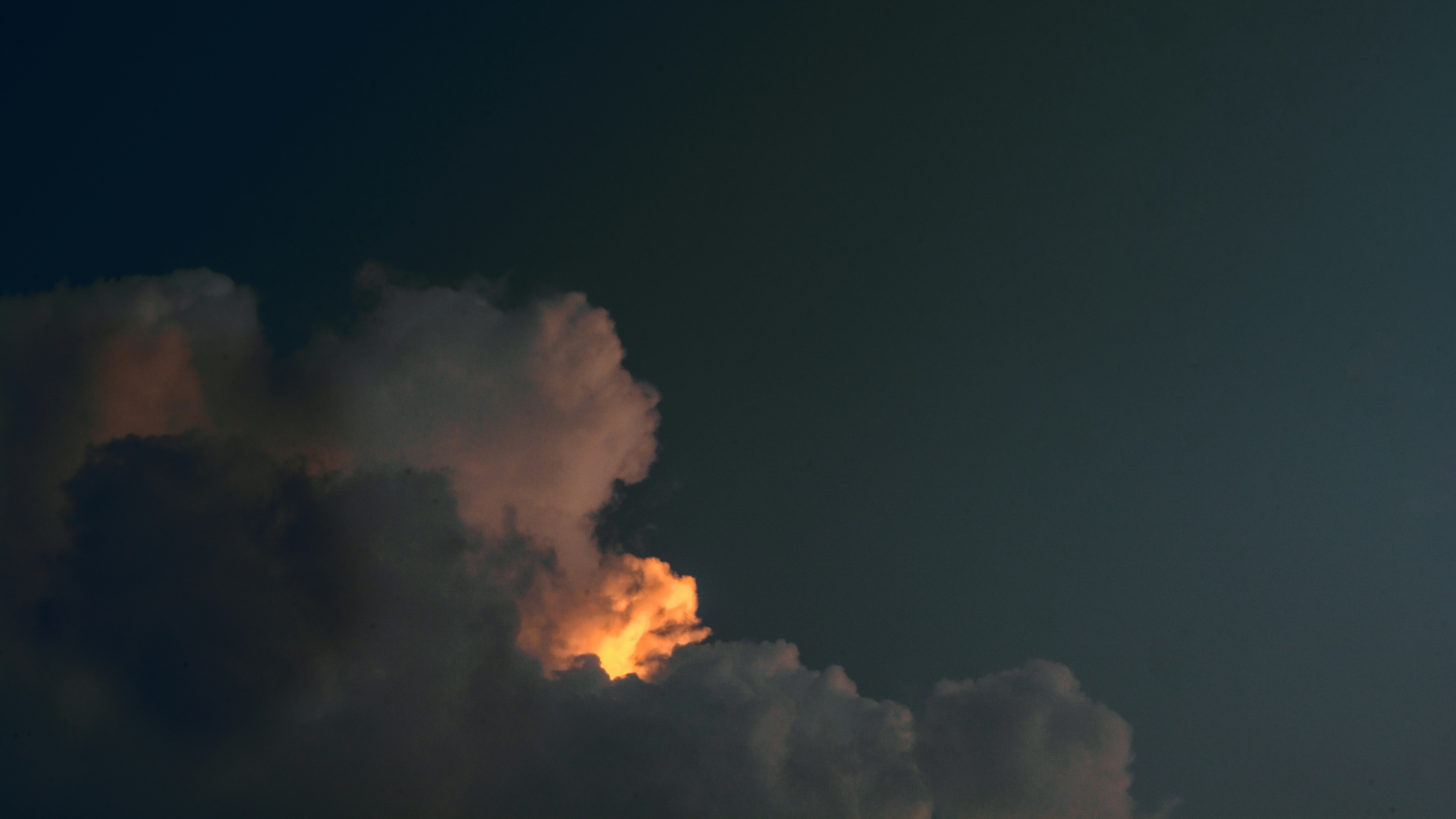 Un jet che vola attraverso un cielo nuvoloso di notte