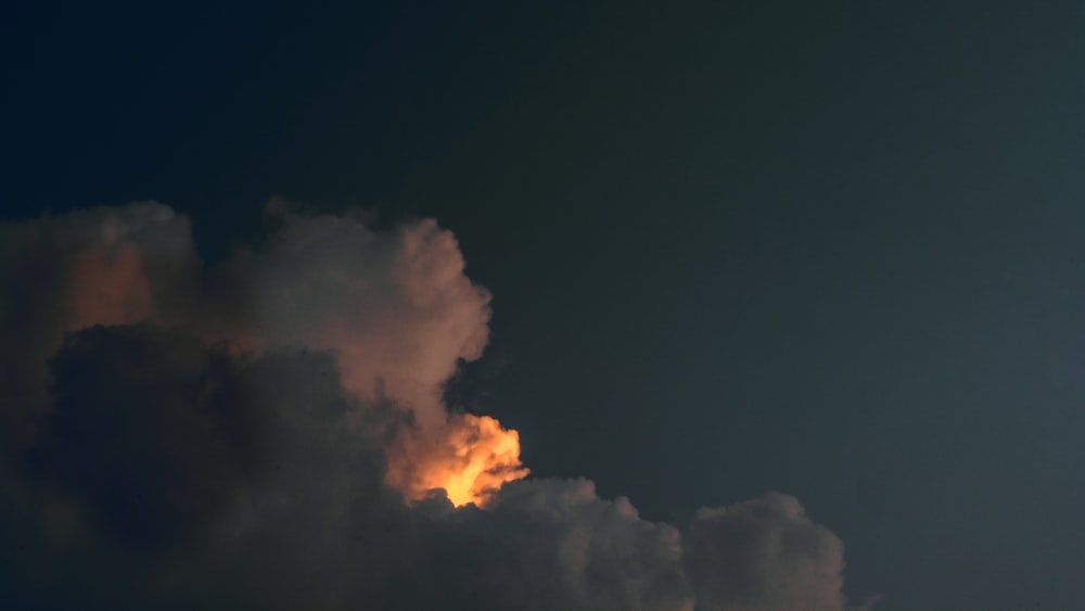 um jato voando através de um céu nublado à noite