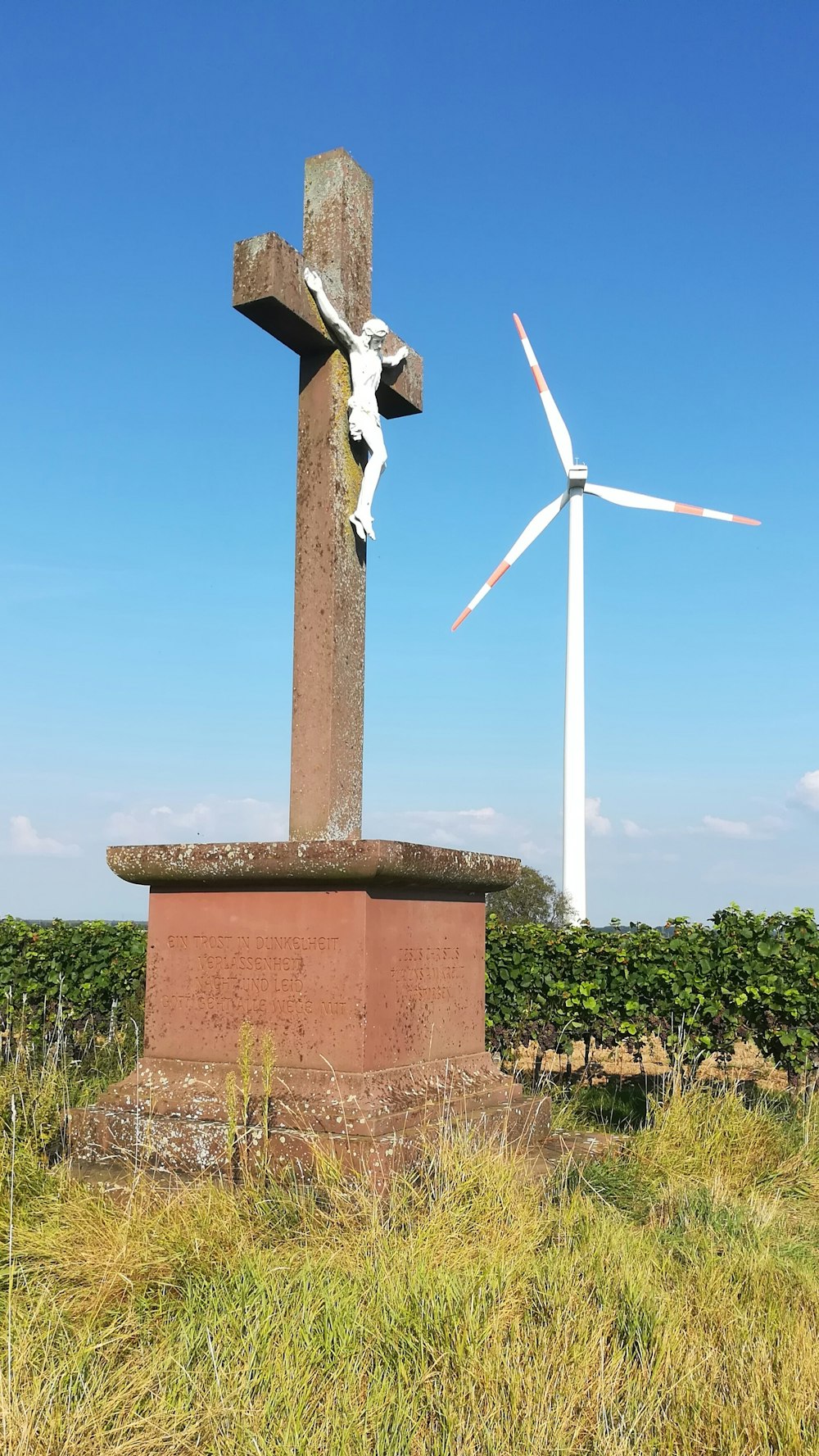 a cross and a wind turbine in a field