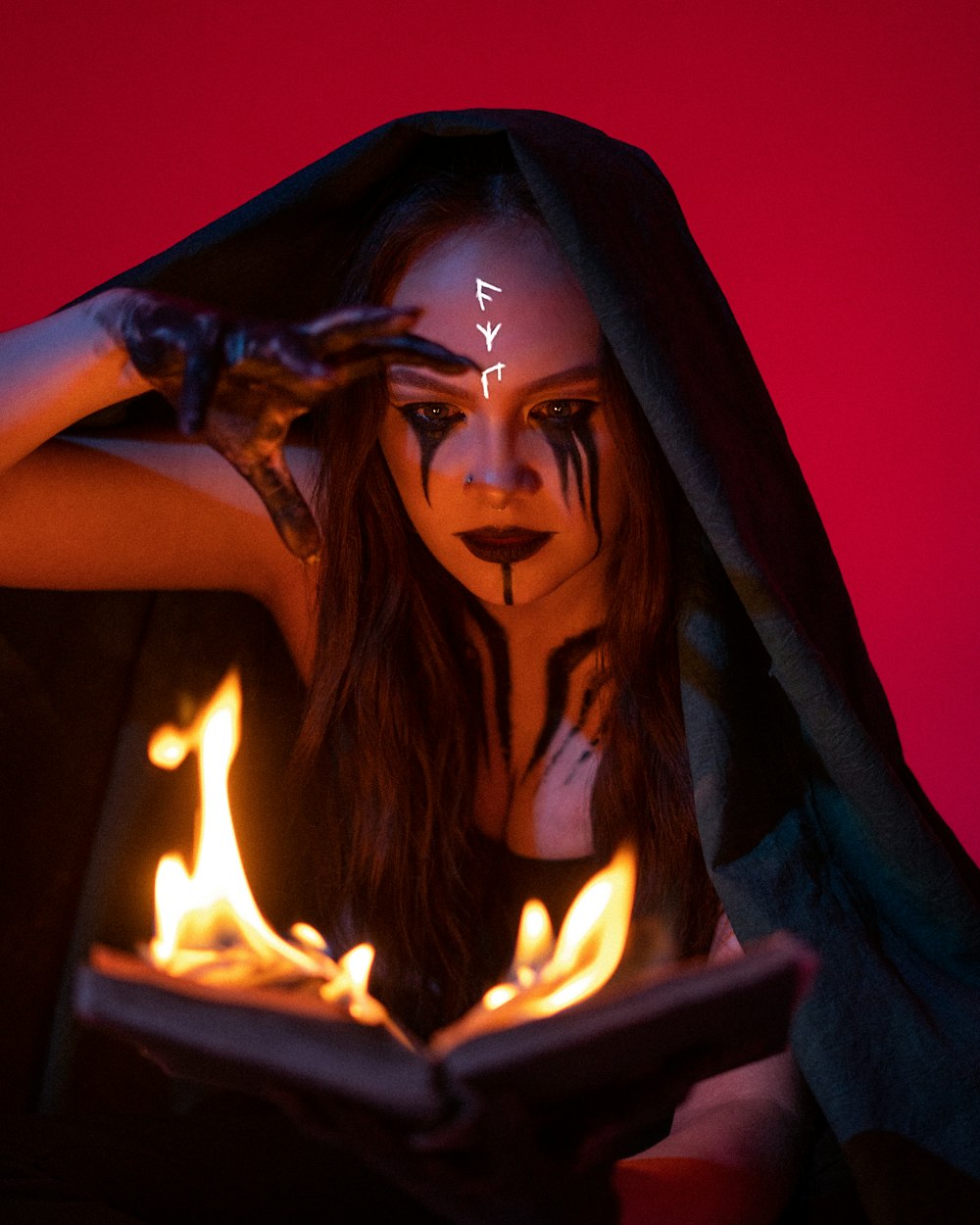 a woman with makeup and makeup art holding a book