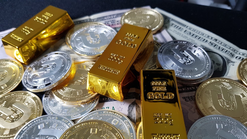 Una pila de lingotes de oro sentados encima de una pila de dinero