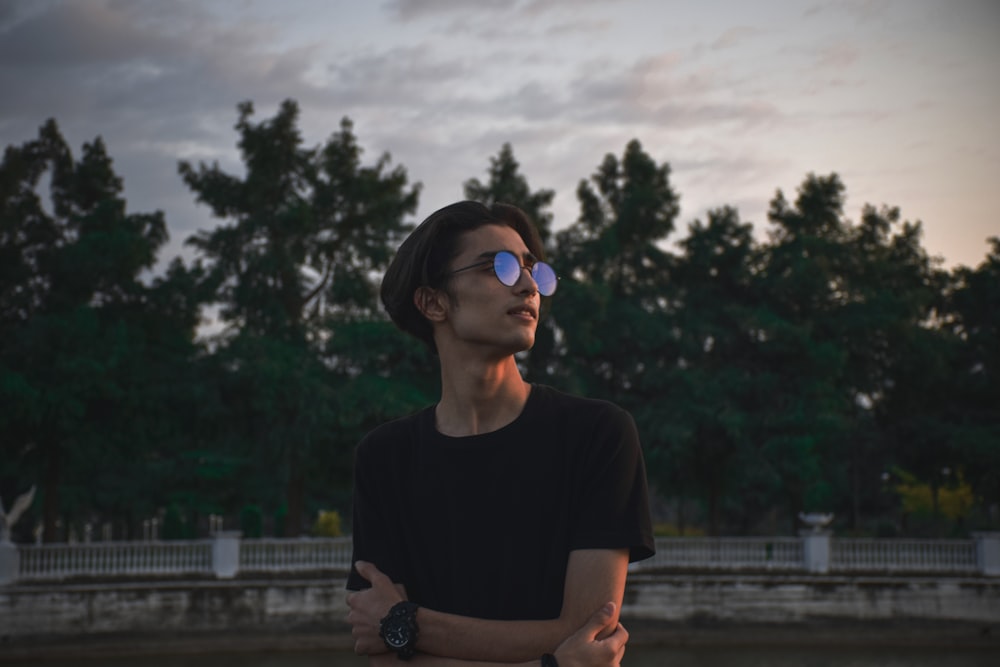 a man in a black shirt and some trees