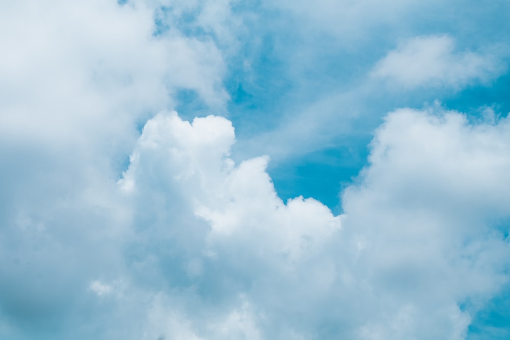 Un aereo che vola attraverso un cielo blu nuvoloso