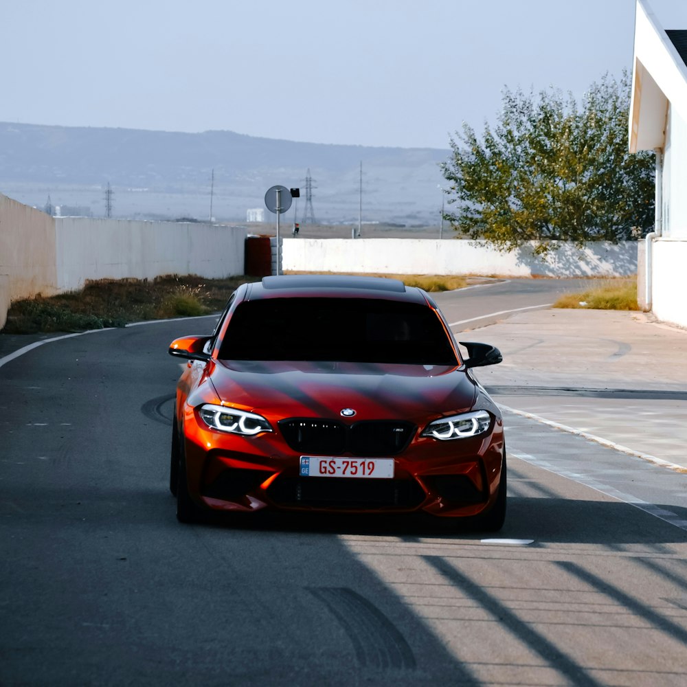 um carro vermelho estacionado na beira de uma estrada